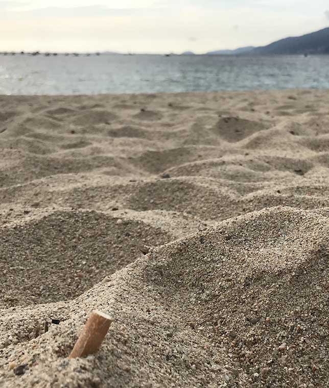 mégot de cigarette dans le sable à la plage